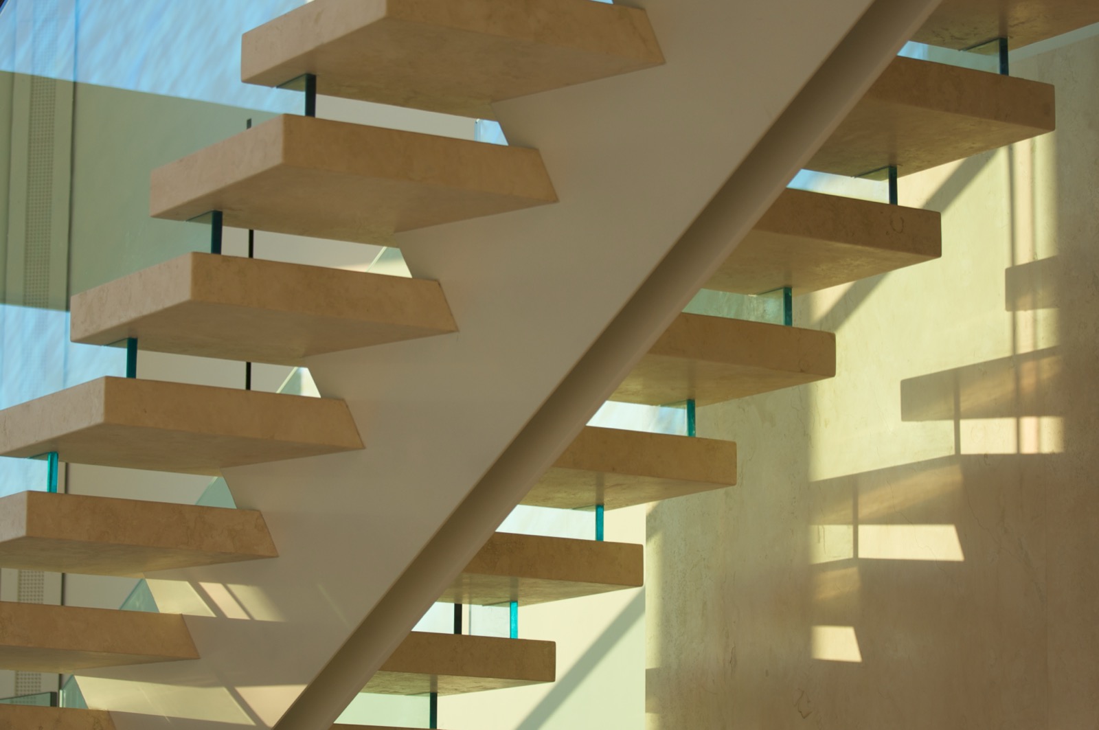 Marble floating stairs with glass railing panels